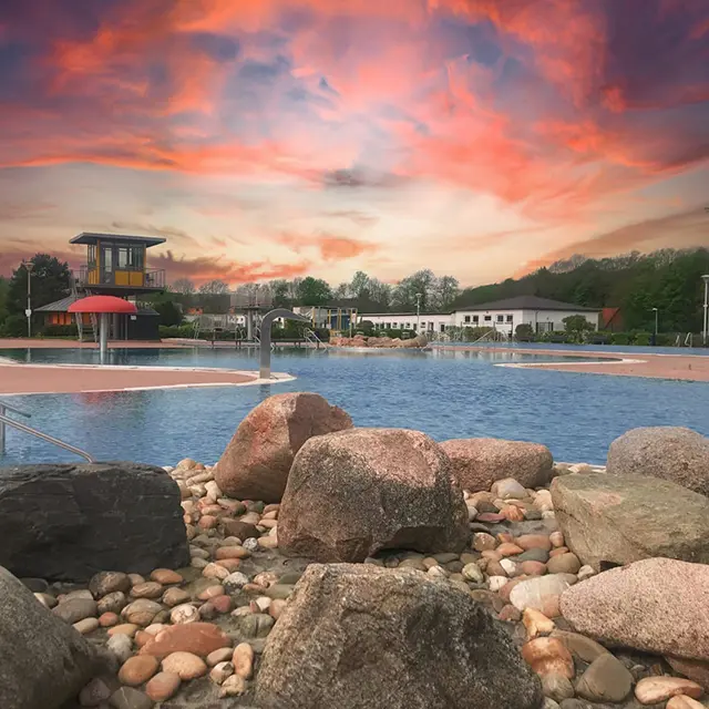 Freibad bei Sonnenuntergang mit Felsen im Vordergrund