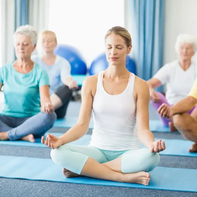 Gruppe beim Meditationskurs auf Yogamatten