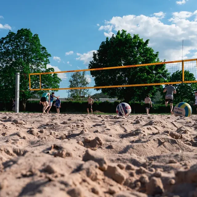 Menschen spielen Beachvolleyball auf dem Sandplatz